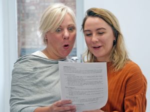 A pupil and her mum look at her A Level results with happy faces.