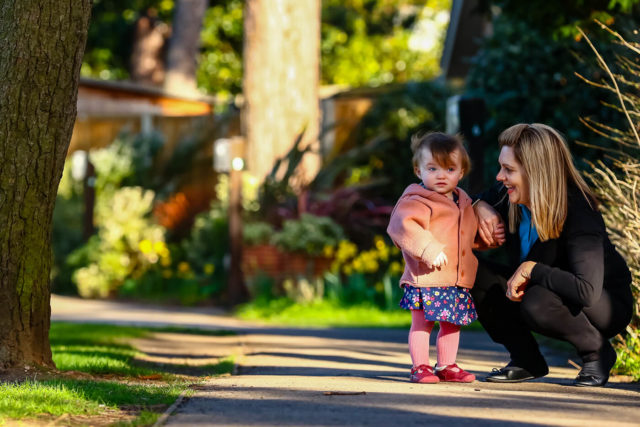 nursery child with nursery assistant in the ground of The Elms day nursery and pre-school