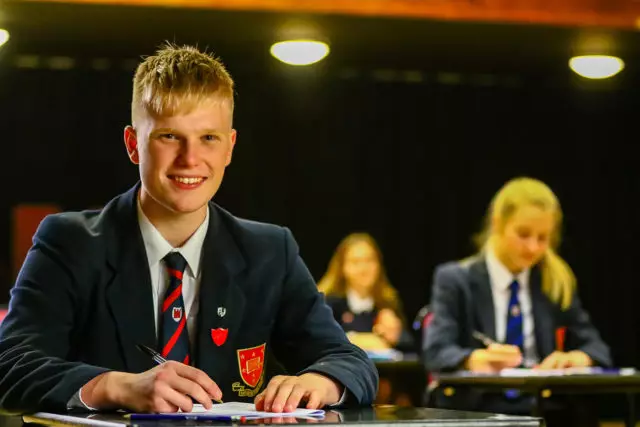 Teenage school boy sat in an examination hall