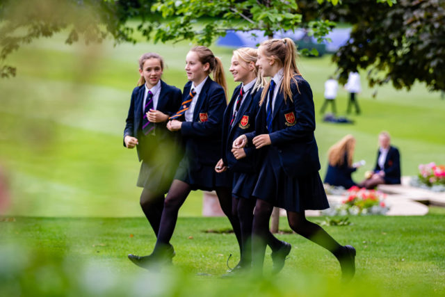 A group of girls talking as they walk in the school grounds