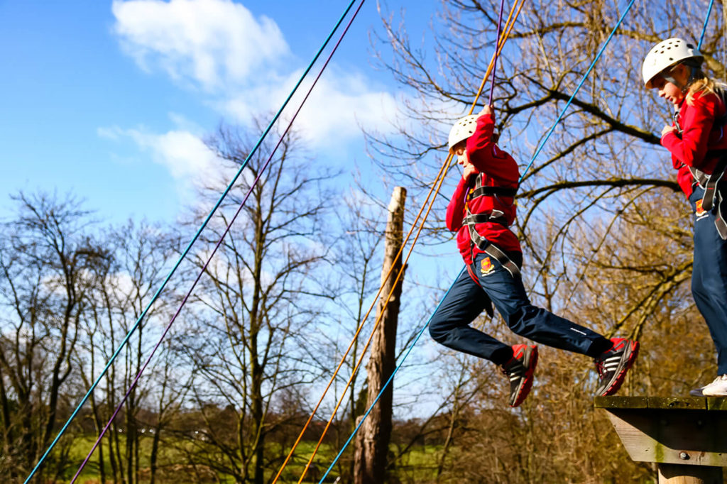 A pupil jumping from the Trent College high ropes course