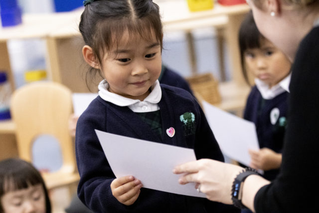 pre-school child receiving guidance from a teacher at The Elms nursery and pre-school