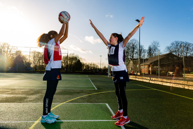 Two young girls playing netball