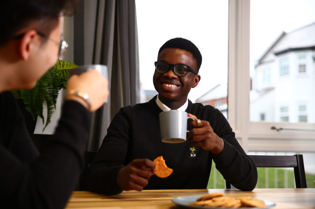 sixth from student sat drinking tea with a friend at a breakfast table