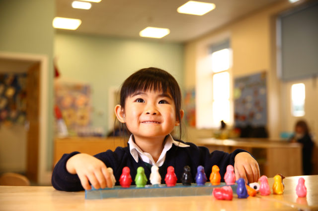 Pre-school child with counting activity inside a classroom