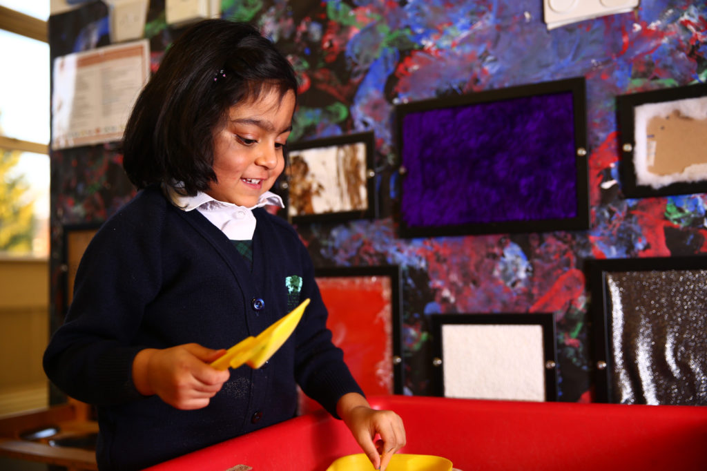 Pre-school child playing at a sandpit in The Elms private day nursery and pre-school