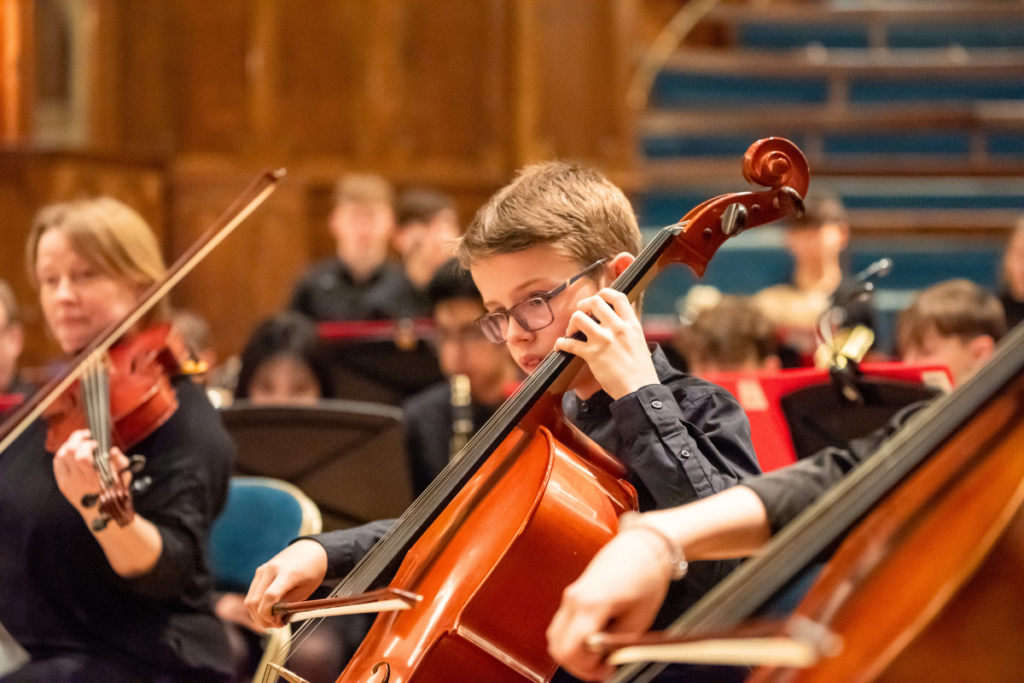 Pupils playing String instruments in a concert.